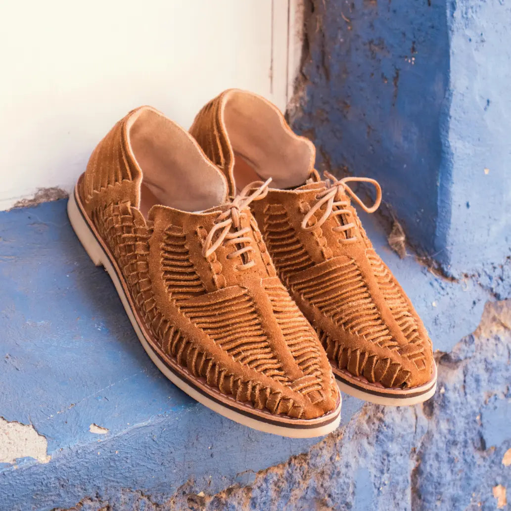 Les Derbies Autentico Suede Caramel sont posées dans l'encadrement bleu d'une fenêtre.