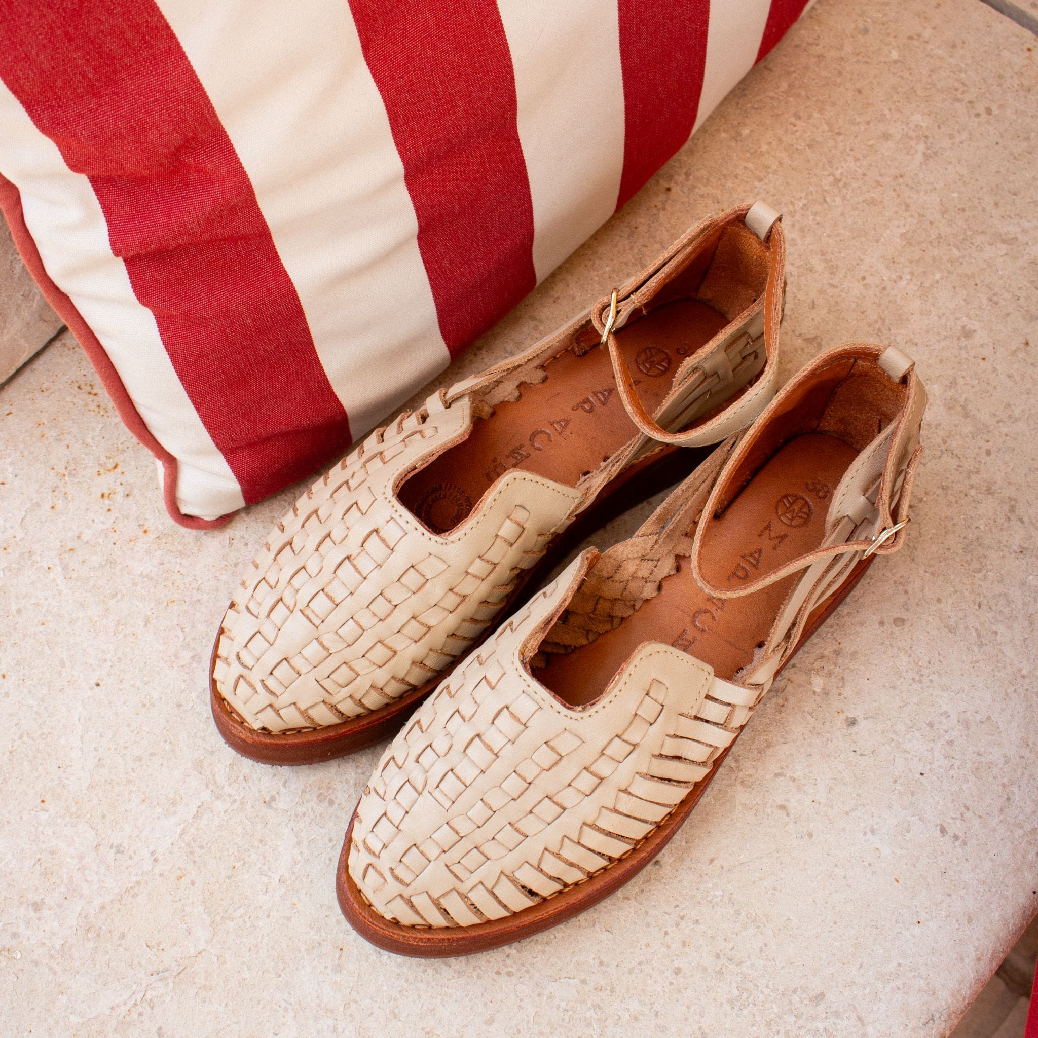 La Carmen Grège est posée sur un banc de pierre, révélant son tressage fin et sa couleur claire.