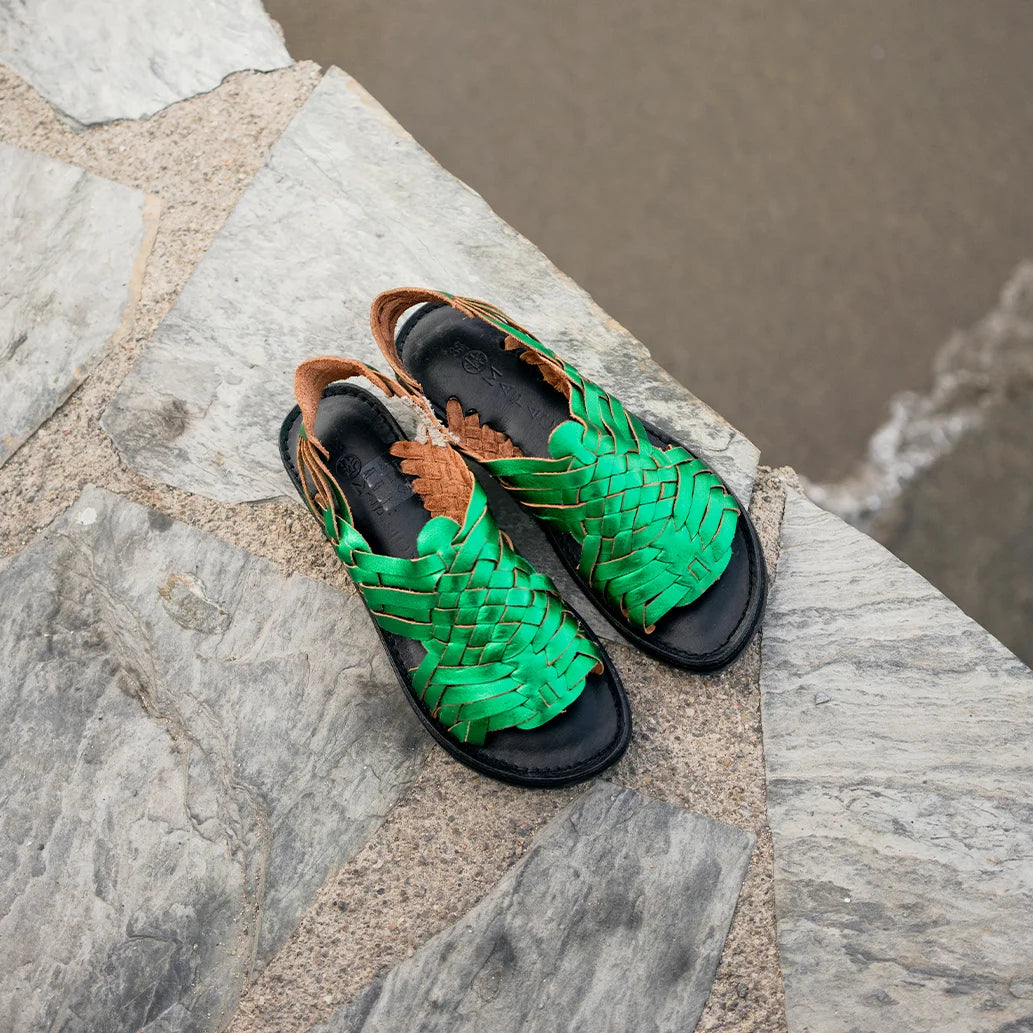 Les Sandales Frida Vert Flashy sont posées sur un mur en ardoise, vues du dessus.