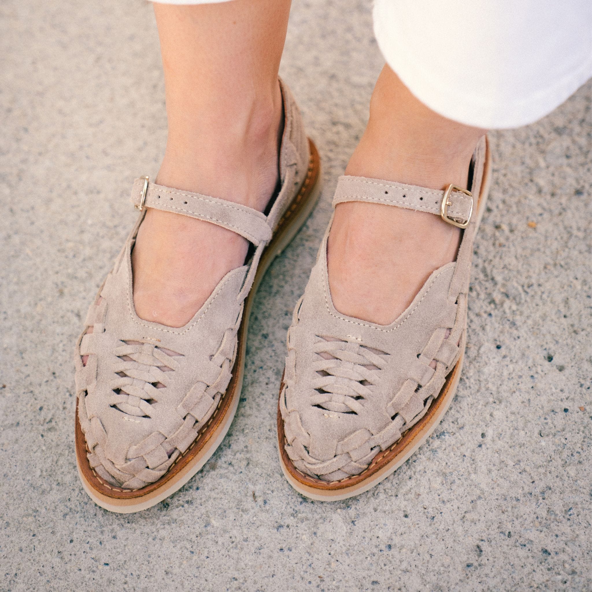 Plan rapproché des pieds de Claire portant les Gaby Suède Taupe.