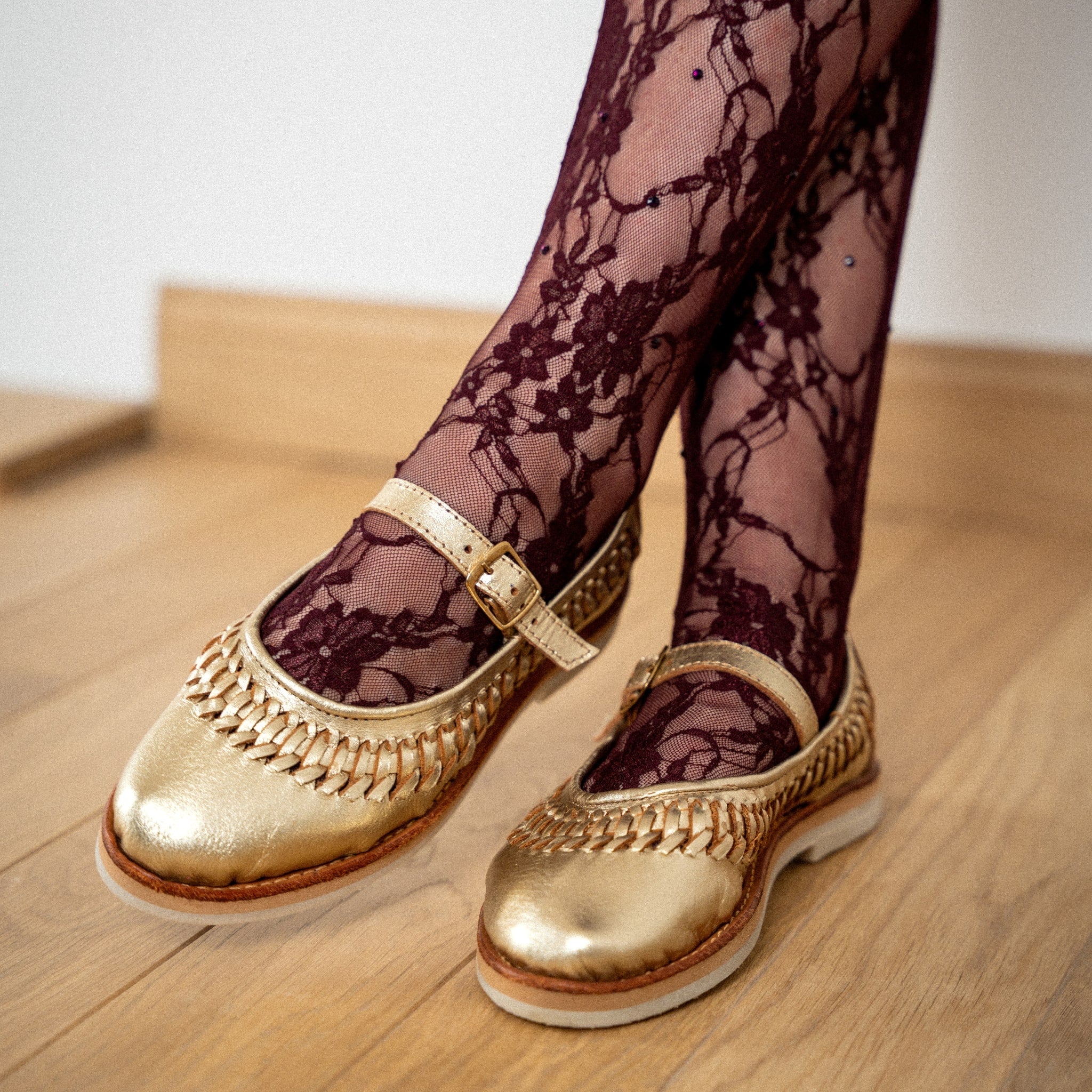 Ballerine Sofia Champagne portée avec un collant bordeaux en dentelle